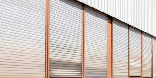 Industry building with shutters on a wall, windows on a metal wall, closed shutters on all windows with alu rollable jalousie, no person